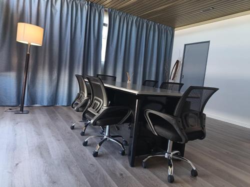 an office with a table with chairs and a lamp at Hotel Iberia in Neuquén