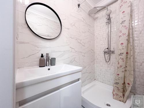 キシナウにあるRentHouse Apartments City Gates #4の洗面台と鏡のある白いバスルーム