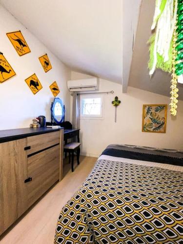 une chambre avec un lit et un bureau dans une pièce dans l'établissement Charmante petite maison avec jardin, à Saint-Cézaire-sur-Siagne