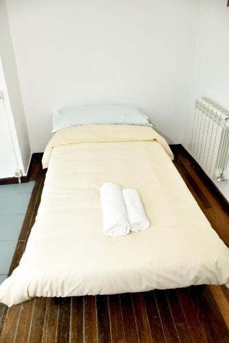 a bed with white sheets and two pillows on it at O lar Albergue Larouco in Laroco