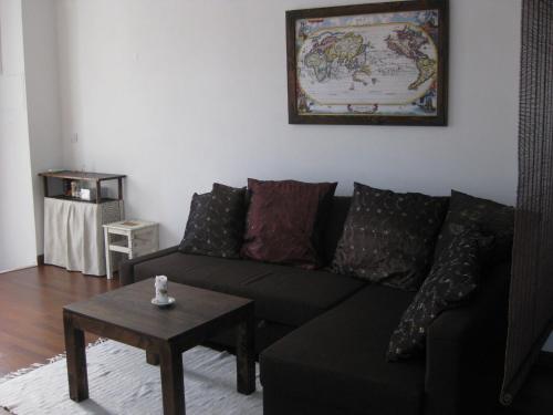 sala de estar con sofá negro y mesa en The Back Yard Nest, en Lisboa