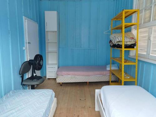 a room with two beds and a blue wall at Casa central 349 in Ponta Grossa