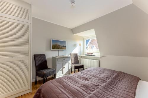 a bedroom with a bed and two chairs and a desk at Sylt Rooms 6 - Long Island Suite in Westerland (Sylt)