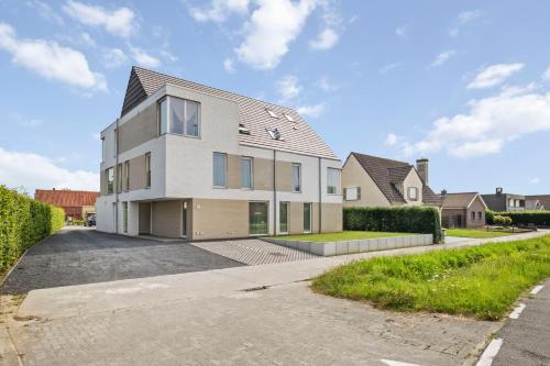 a large white house with a driveway at Chez Victorine Zulte in Zulte