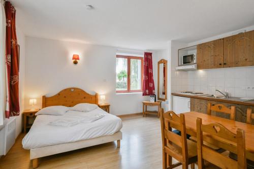 une chambre avec un lit et une cuisine dans l'établissement Studio entre Lac et Montagnes Evian - Lugrin, à Lugrin