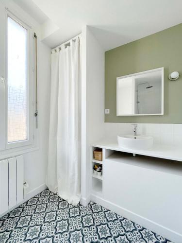 une salle de bain avec un lavabo et un miroir dans l'établissement Ma Belle Conciergerie - Le Cocon Mélunais, à Melun