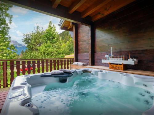 une baignoire jacuzzi sur la terrasse d'une maison dans l'établissement Chalet Chavanette - OVO Network, à Châtel