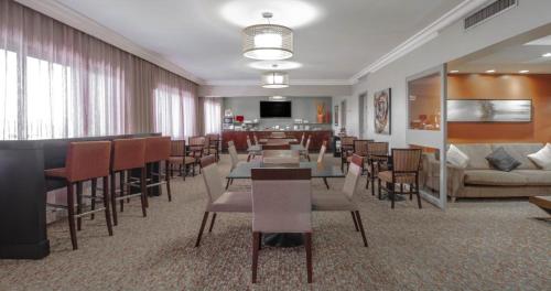 a dining room with tables and chairs and a couch at Marriott São Paulo Airport Hotel in Guarulhos