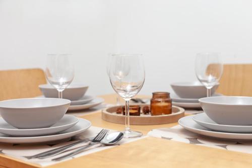 a table with plates and wine glasses on it at Beautiful 3 Bedroom Flat In Scott Ellis Gardens in London