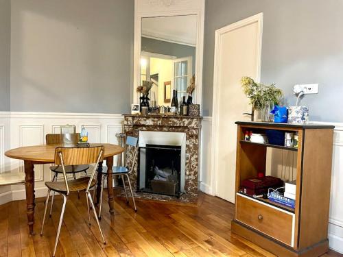 une salle à manger avec une table et une cheminée dans l'établissement Apartment Paris - Tour Eiffel - Bail Mobilité, à Paris