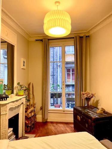 - une chambre avec une cheminée et une grande fenêtre dans l'établissement Apartment Paris - Tour Eiffel - Bail Mobilité, à Paris