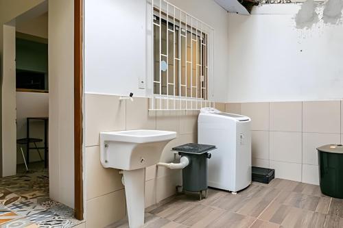 a bathroom with a sink and a refrigerator at Casa central em ótima localização - UN059 in Florianópolis