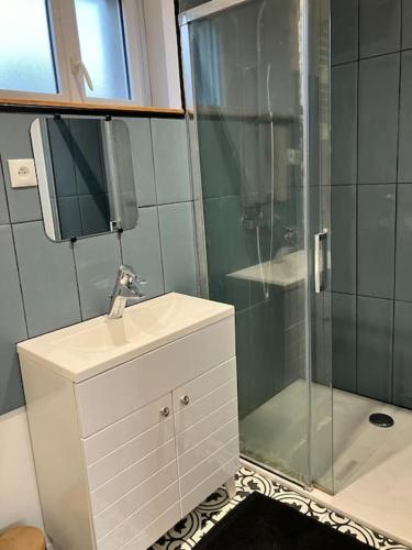 une salle de bain avec un lavabo et une douche dans l'établissement Longère proche de la mer, à Guidel