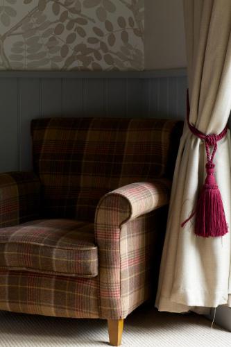 a couch sitting next to a window with a curtain at Pear Tree Inn Whitley in Whitley