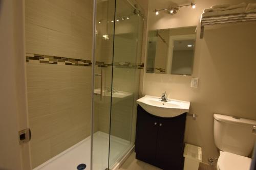 een badkamer met een glazen douche en een wastafel bij The Lion Inn & Suites in Chetwynd
