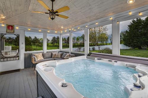 a large hot tub on a screened porch with a ceiling at Amazing House - Movie & Game Room, Hot Tub, Fire Pit & Golf Course in Luray