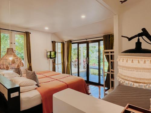 a bedroom with two beds and a balcony at Baan Bua Cottage SHA EXTRA PLUS B5510 in Ko Kood