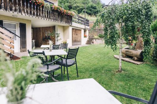 a patio with tables and chairs in a yard at Hotel Schönwies in Trodena