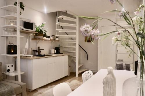 a kitchen and living room with a table and flowers at Cavalli's Cottage in Bilthoven