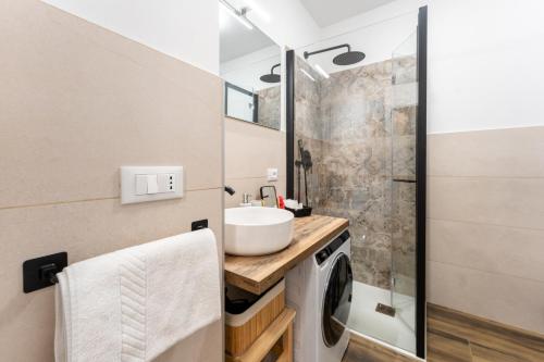 ガッリオにあるElegante Bilocale con balcone - Perfetto per coppieの洗面台と洗濯機を備えたバスルーム
