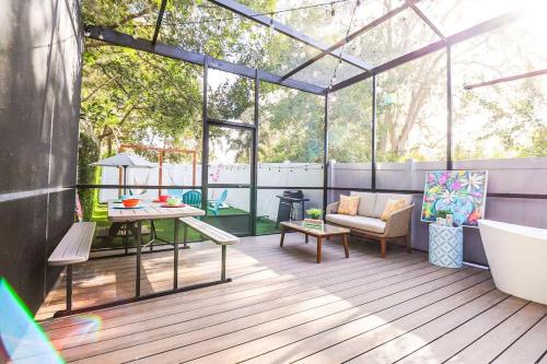 a screened in porch with a tub and a table at FunTropicalTinyHomeGolfCartLake in Orlando