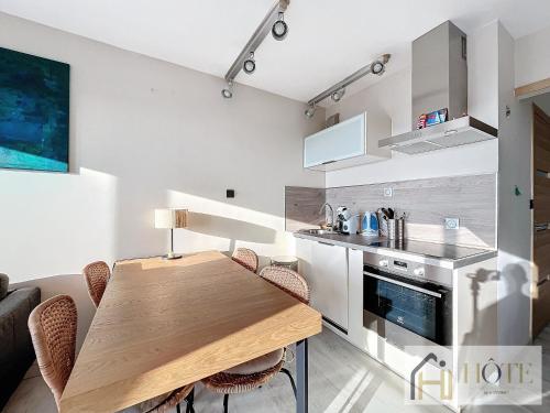 - une cuisine avec une table en bois dans une chambre dans l'établissement Sable & Horizon - Vue Mer - 7e étages, à Bray-Dunes