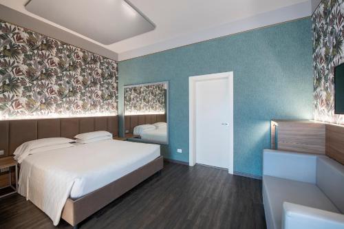 a bedroom with a white bed and a blue wall at MO.OM Hotel in Olgiate Olona