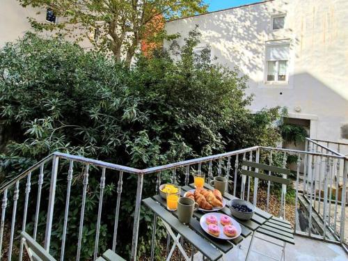 - un plateau de nourriture sur une table sur un balcon dans l'établissement coocon - coeur de ville - terrasse, à Nîmes