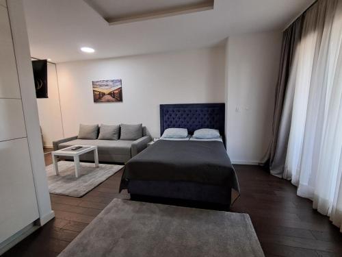 a bedroom with a bed and a couch at Apartment Premier 2 A Blok in Belgrade