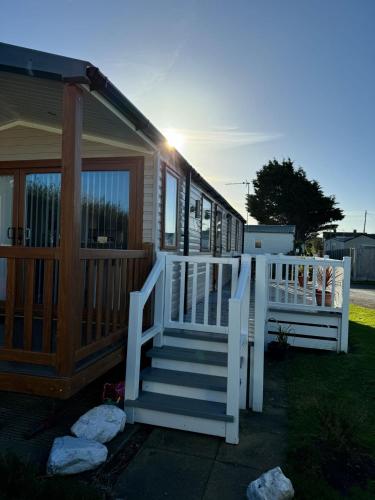 a house with a white staircase and a porch at Flower Bay in Prestatyn