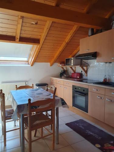 une cuisine avec une table, des chaises et une cuisinière dans l'établissement Appartement proche du lac ,piscine ouverte de mars a octobre, à Thonon-les-Bains