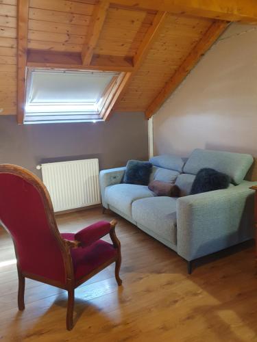 un salon avec un canapé et une chaise dans l'établissement Appartement proche du lac ,piscine ouverte de mars a octobre, à Thonon-les-Bains