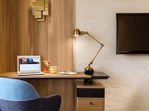 a desk with a laptop and a lamp on it at JEN Singapore Tanglin by Shangri-La in Singapore