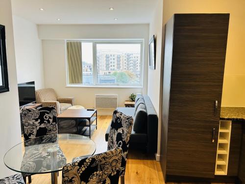 a living room with a table and chairs at London Heathrow Apartment - Hayes & Harlington in Hayes