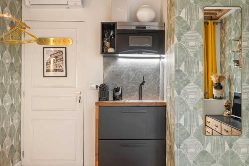 une petite cuisine avec un évier et un réfrigérateur dans l'établissement Superb Historical Studio next to Louvre and Opera, à Paris