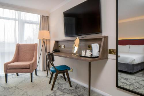 a hotel room with a desk with a bed and a chair at London Croydon Aerodrome Hotel, BW Signature Collection in Croydon