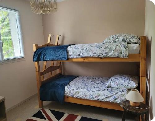 two bunk beds in a room with a lamp at La petite maison in Pontis