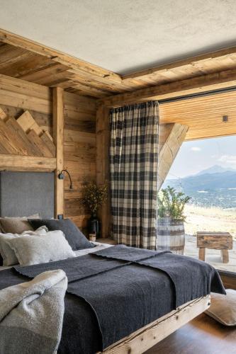 a bedroom with a large bed and a large window at Mountain Shelter Salamandra in Kościelisko