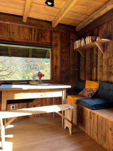 une chambre avec un banc et une fenêtre dans une cabine dans l'établissement Chalet cabane pleine nature, à Le Bouchet-Mont Charvin