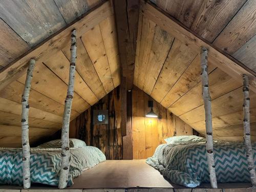 1 Schlafzimmer mit 2 Betten an einer Holzdecke in der Unterkunft Chalet cabane pleine nature in Le Bouchet-Mont Charvin