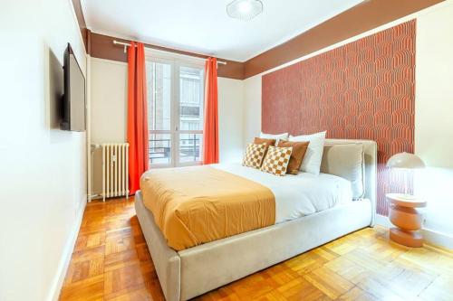 - une chambre avec un lit doté de rideaux orange et d'une fenêtre dans l'établissement Confort et tranquillité à Neuilly-sur-Seine, à Neuilly-sur-Seine