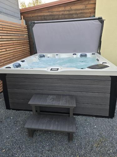 a jacuzzi tub with a bench in front of a building at Apartmány Centro & Jacuzzi in Piešťany