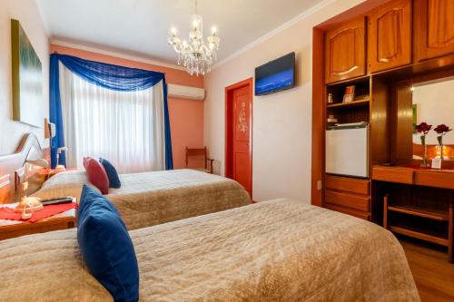 a hotel room with two beds and a television at Hotel Pousada da Neve in Nova Petrópolis