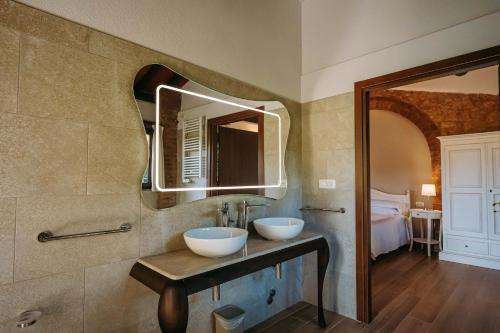 a bathroom with two white sinks and a mirror at Borgo Il Poggiaccio Residenza d'Epoca in Sovicille