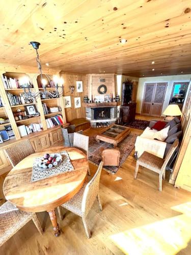un salon avec un plafond en bois et une table et des chaises dans l'établissement Très bel appartement à Megève, à Megève