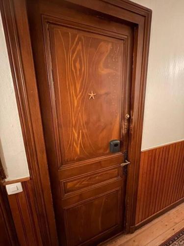 une porte en bois avec une peinture sur celle-ci dans l'établissement Studio cosy avenue de la mer, à Cabourg