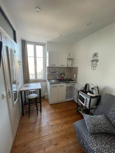- une cuisine avec un canapé et une table dans une chambre dans l'établissement Studio cosy avenue de la mer, à Cabourg