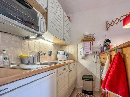 une petite cuisine avec un évier et un micro-ondes dans l'établissement Le Petit Sylvio, au Grand-Bornand