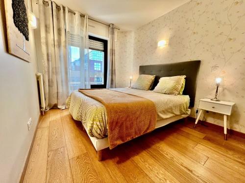 une chambre avec un grand lit et une fenêtre dans l'établissement 2 Pieces 50m2 proche metro, à Levallois-Perret