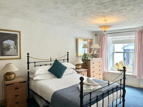 a bedroom with a large bed and a window at Ship Cottage Tenby Beach 50m in Pembrokeshire